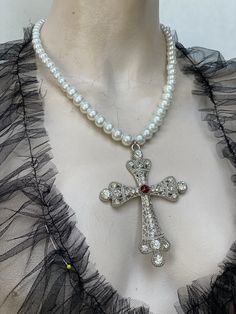 Large filigree cross pendant pearl chain. Cross has clear rhinestone, and red Swarovski crystal in the center. I have used three sizes white pears for the chain 10 mm , 8 mm and 6 mm glass pearls. Cross is zinc alloy. I can do any colour pearls to suit you. Vkei Jewellery, White Cross-shaped Rhinestone Jewelry, White Cross-shaped Jewelry With Rhinestones, White Rhinestone Cross Jewelry, White Crystal Cross Necklaces, White Crystal Cross Pendant Necklace, White Cross Jewelry For Party, Elegant Cross Necklace With Pearl Drop, White Cross Pendant Necklace For Wedding