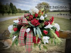 a red and white flower arrangement tied to a wooden fence with the words mth designs on it