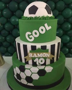 a three tiered cake with a soccer theme on it's top and bottom layer