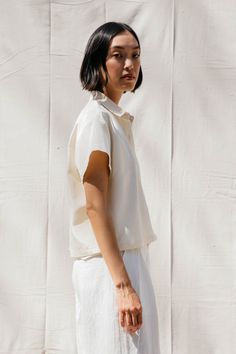 Short sleeved cropped, boxy buttondown with front pocket and shell buttons. Classic White Cropped Shirt For Daywear, White Button-up Blouse With Buttoned Pockets, White Collared Cropped Shirt For Work, White Relaxed Fit Cropped Button-up Shirt, White Blouse With Buttoned Pockets For Work, White Cropped Buttoned Shirt For Work, Casual Cropped Blouse With Button Cuffs, White Cropped Shirt For Everyday, Everyday White Cropped Shirt