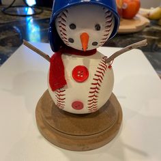 a snowman made out of baseballs with a blue hat and red scarf on