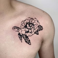 a black and white tattoo of a turtle with flowers on it's back shoulder