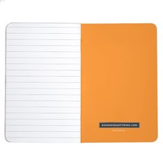 an orange and white notebook with writing on the front, blank paper in the back