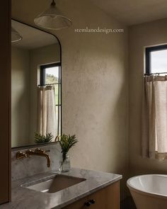 a bathroom with a tub, sink and window