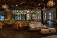 a room with tables, couches and chandeliers