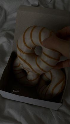 there is a box with donuts in it that are white and gold stripes on the inside