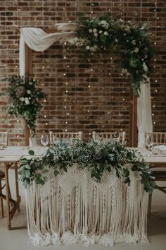 the table is decorated with greenery and candles