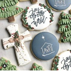 decorated christmas cookies with handwritten words and trees are on the table next to each other