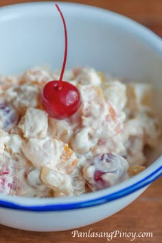 a white bowl filled with fruit salad on top of a wooden table