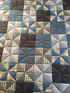 a quilt that has been made with different colors and patterns on it, including blue, brown