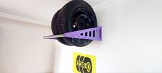 a purple tire mounted to the side of a wall