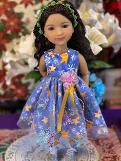 the doll is wearing a blue dress with stars on it