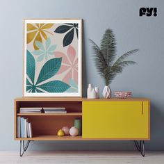 an art print on the wall above a yellow cabinet