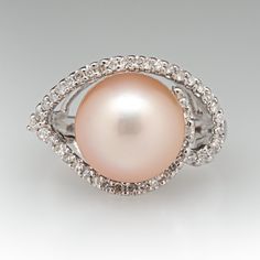 This beautiful ring is centered with one (1), post set, cultured saltwater pearl. The pearl is bordered with forty-five (45), prong set, round single cut diamonds. The ring measures 13.8mm at the top, rises 11.4mm above the finger, tapering to 2.1mm wide and 0.8mm thick at the base of the shank. This ring is currently a size 5. Diamond Pearl Ring With Pave Setting For Formal Events, Diamond Pearl Ring With Pave Setting For Formal Occasions, Formal Diamond Pearl Ring With Pave Setting, Diamond Pearl Ring With Pave Setting For Anniversary, Formal Diamond White Pearl Ring With Diamond Accents, Formal Pearl Ring With Diamond In Round Cut, Fine Jewelry Pearl Ring With Diamond Accents, Formal Diamond Pearl Ring With Round Cut, Formal Pearl Ring With Diamond