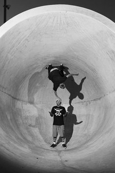 two skateboarders in black and white are doing tricks on a ramp at a skate park