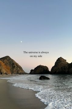 an ocean beach with rocks and the words, the universe is always on my side