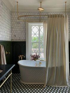 a bath tub sitting next to a window in a bathroom