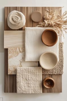 an arrangement of bowls, plates and napkins on top of a wooden table cloth