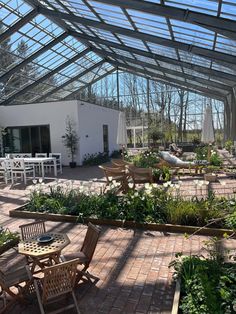 the inside of a greenhouse with tables and chairs