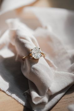 a diamond ring sitting on top of a white cloth