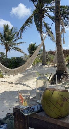 a coconut sitting on top of a wooden table next to a hammock