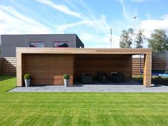 a modern house with an attached carport in the front yard and large grass area