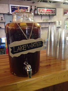 there is a large jar of liquid on the counter with paper tags attached to it