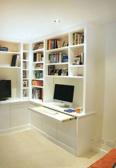 a computer desk sitting in front of a bookshelf