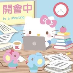 there is a hello kitty sitting at a desk with a laptop and books on it