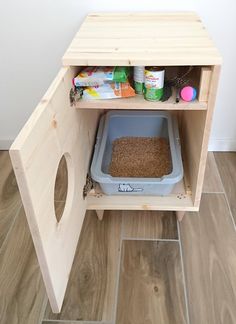 a cat litter box in the corner of a cabinet