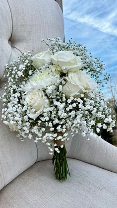 a bouquet of white flowers sitting on top of a chair