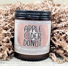 a jar of apple cider donut sitting on top of wood shavings