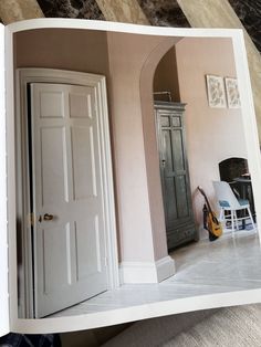 an open photo book with a guitar in the corner next to a chair and fireplace