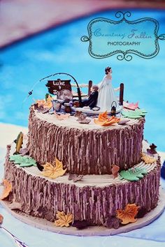 a wedding cake sitting on top of a table next to a swimming pool with fall leaves