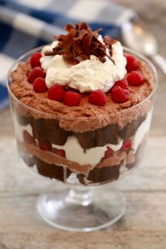 a dessert with chocolate, raspberries and whipped cream in a trifle dish