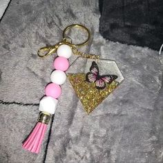 a keychain with a pink and white beaded tassel hanging from it