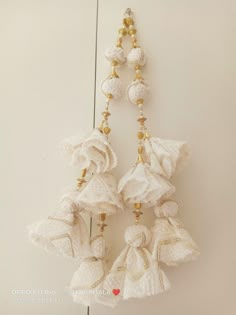 two white tassels hanging from a hook on a wall with gold trimming