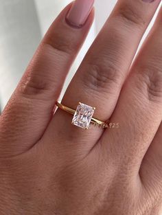 a woman's hand with a ring on it and a diamond in the middle