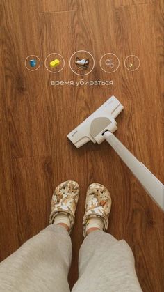 a person standing on the floor next to a mop and remote control for cleaning