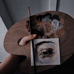 a person holding a pencil and drawing on a piece of paper with an image of a woman's face