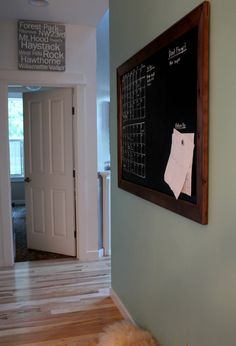 a dog laying on the floor in front of a chalkboard with writing on it