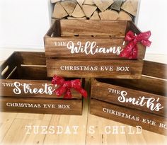 four wooden boxes with christmas sayings on them sitting on a wood floor next to firewood