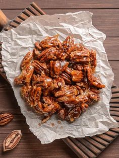 a pile of pecans sitting on top of a wooden table next to some nuts