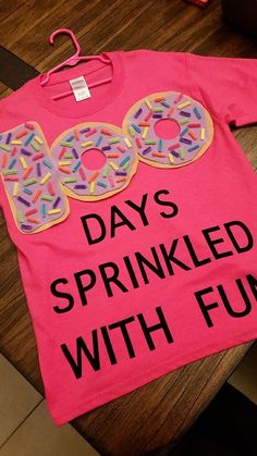 a pink shirt with sprinkled donuts on it