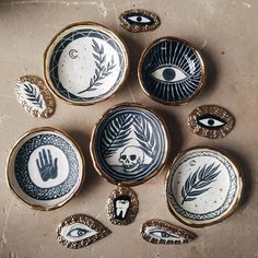 six decorative plates with hand and eye designs on them, all decorated in different styles