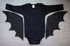 a black bodysuit with two bats cut out on the front, and one in the back