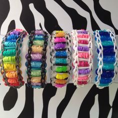 there are many different bracelets hanging on the wall in front of zebra print background