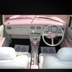 the interior of a pink and white car