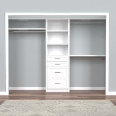 an empty white closet with shelves and drawers on the floor, in front of a gray wall