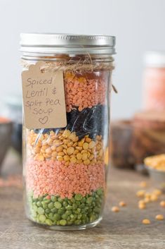 a jar filled with beans and peas on top of a table